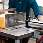 after-aging-the-pressed-blocks-are-moved-into-the-cutting-room-for-cutting-and-packaging-the-cheese-blocks-are-pushed-through-wire-cheese-cutters